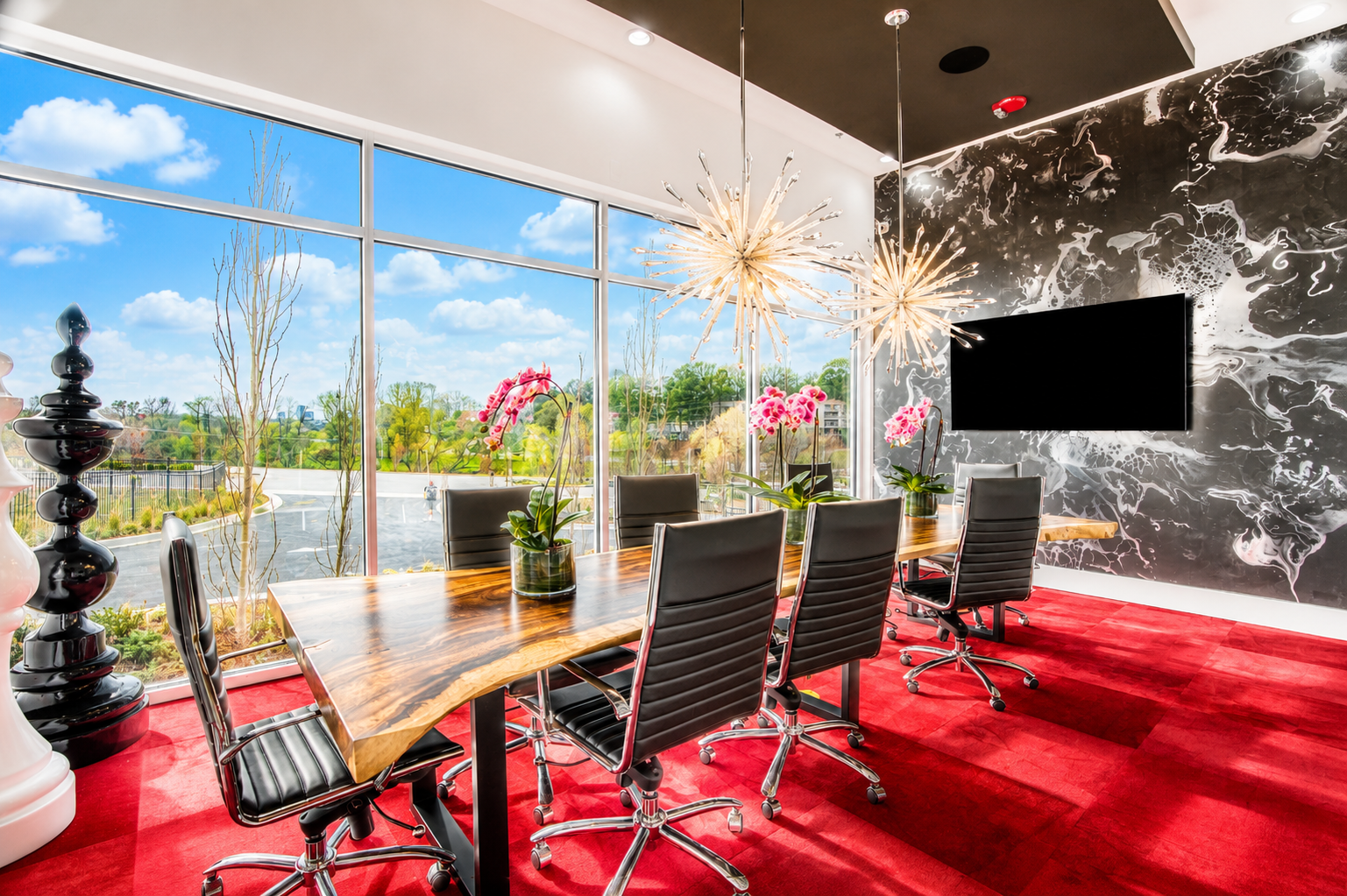 Modern conference room at Modern Storage® North Little Rock featuring executive seating, floor-to-ceiling windows, red carpeting, and designer lighting.